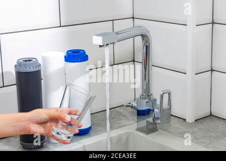 Le robinet d'où s'écoule l'eau. Soif étouffant. Problèmes d'eau dans certains pays.le verre est rempli d'eau. Banque D'Images