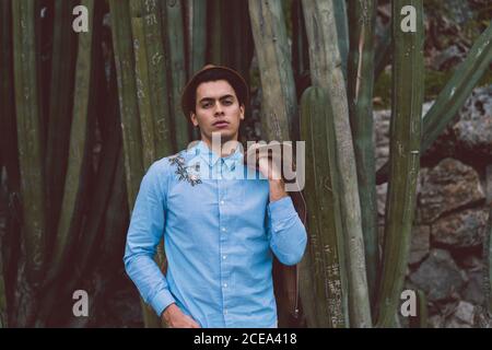 Jeune homme attentionné au cactus Banque D'Images