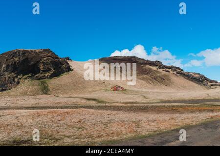 Paysage de petite maison rouge dans la vallée au pied de Montagnes en Islande Banque D'Images