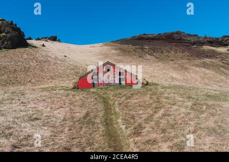 Paysage de petite maison rouge dans la vallée au pied de Montagnes en Islande Banque D'Images