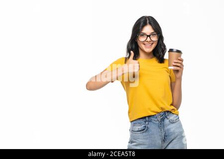 Jeune belle femme buvant une tasse de café sur fond blanc isolé heureux avec grand sourire faisant signe ok, pouce vers le haut avec les doigts, signe excellent Banque D'Images