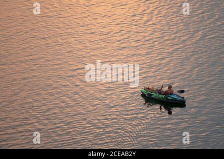 Austin, Texas, États-Unis, 18 août 2020 : les pagayeurs dans un kayak vert vif apprécient le coucher du soleil après une chaude journée d'été sur le lac Lady Bird dans le centre-ville d'Austin. ©Bob Daemmrich Banque D'Images
