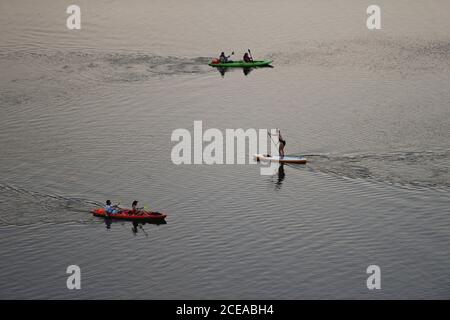 Austin, Texas, États-Unis, 18 août 2020 : un homme sur un stand-up paddle board et les pagayeurs dans des kayaks profiter du coucher du soleil après une chaude journée d'été sur le lac Lady Bird dans le centre-ville d'Austin. ©Bob Daemmrich Banque D'Images