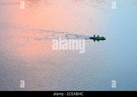 Austin, Texas, États-Unis, 18 août 2020 : les pagayeurs dans un kayak vert vif apprécient le coucher du soleil après une chaude journée d'été sur le lac Lady Bird dans le centre-ville d'Austin. ©Bob Daemmrich Banque D'Images