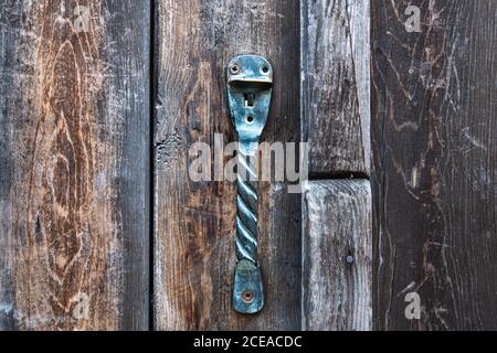 Poignée de porte en fer métallique vintage sur une vieille porte en bois naturel. Orientation horizontale, mise au point sélective. Porte-outil Banque D'Images