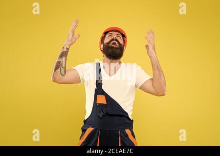 Enfin. Tendance de l'environnement technique. Casque de chantier. Amélioration et rénovation. Homme de construction brutal. Employé de type barbu sur fond jaune. Uniforme du constructeur ingénieur. Décoration de la maison. Sentez le soulagement. Banque D'Images