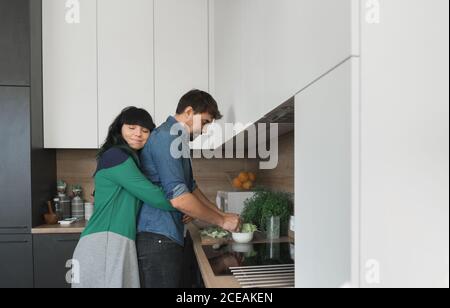 Joyeux couple cuisine dans la cuisine ensemble Banque D'Images