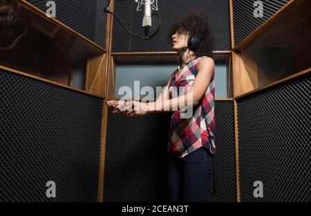 Jeune femme chantant en studio Banque D'Images