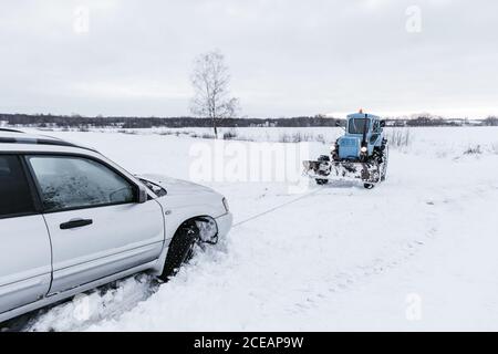 Le remorquage du tracteur casse automobile de neige sur prairie à Vilnius, Lituanie Banque D'Images