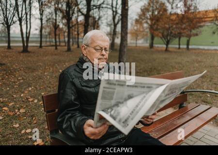 Homme âgé lisant le journal dans le parc Banque D'Images