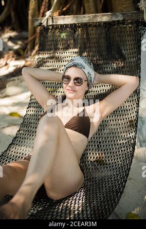 Belle jeune femme couchée et relaxante dans un hamac sur la plage en Thaïlande. Banque D'Images
