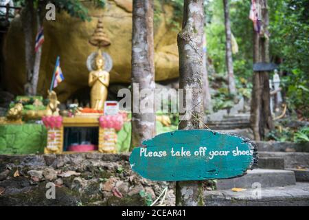 S'il vous plaît enlever vos chaussures panneau en bois à la statue de Bouddha doré en Thaïlande. Banque D'Images