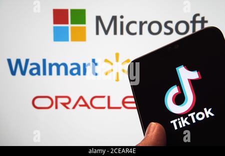Stone / UK - août 31 2020 : logo TikTok sur l'écran mobile et logos flous de Microsoft, Walmart, Oracle sur l'écran flou au dos. Non Banque D'Images