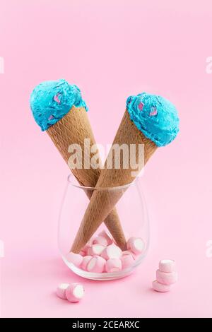 Crème glacée colorée bleue servie dans un cornet de gaufres avec guimauve en verre. Banque D'Images