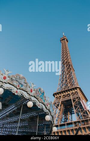 Depuis le dessous du carrousel coloré et la tour Eiffel dans un ciel clair à Paris, France. Banque D'Images