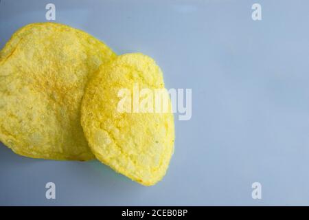 Gros plan de deux délicieux chips de pomme de terre sur la gauche côté d'arrière-plan bleu clair Banque D'Images