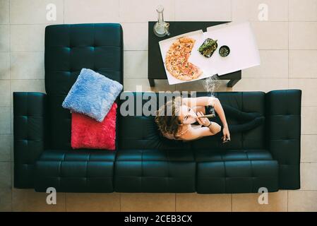 Femme allongé sur un canapé avec un joint de marijuana Banque D'Images