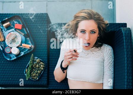 Jeune femme fumant un joint de cannabis Banque D'Images