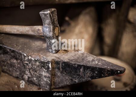 Vue rapprochée de la récolte d'un marteau reposant sur une enclume métallique usine de moulage Banque D'Images