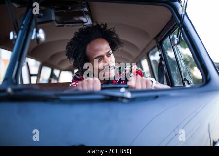 beau afro homme aime le voyage dans son minibus d'époque avec quelques amis Banque D'Images