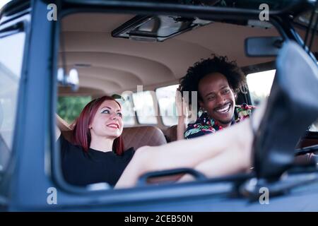 beau afro homme aime le voyage dans son minibus d'époque avec quelques amis Banque D'Images