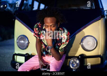 beau afro homme aime le voyage dans son minibus d'époque avec quelques amis Banque D'Images