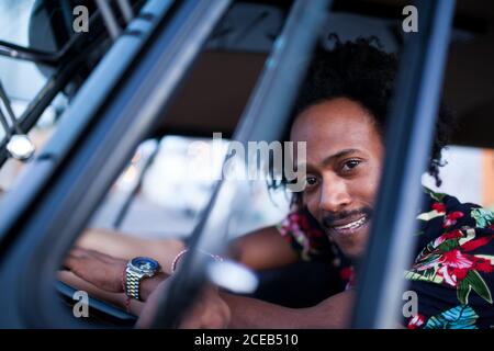 beau afro homme aime le voyage dans son minibus d'époque avec quelques amis Banque D'Images