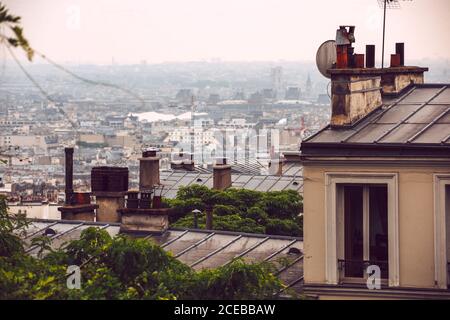 Vue d'en haut sur les arbres et les toits de la maison couverts avec Brouillard à Paris Banque D'Images