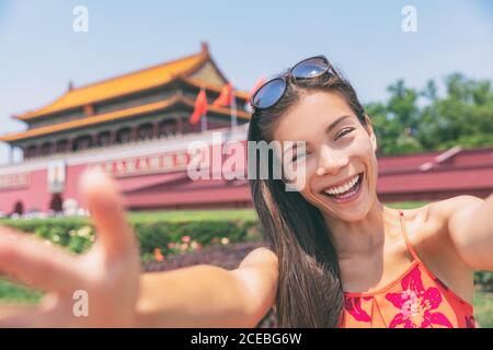 Fille touristique asiatique prenant photo selfie avec téléphone à la place Tiananmen dans la ville de Beijing, Chine. Asie voyage femme chinoise style de vie. Banque D'Images