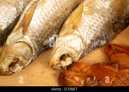 Poisson séché et caviar séché sur un panneau de service en bois. Gros plan Banque D'Images