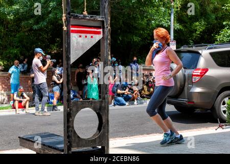 Washington, DC, Etats-Unis, 27 août 2020. Photo: Un jogger de quartier passe par le Rallye pour les droits des travailleurs, près d'une guillotine avec le Distric Banque D'Images