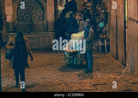 31 décembre 2017 - Marrakech, Maroc : homme natif debout avec une calèche et femme marchant dans la rue Banque D'Images