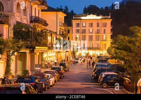 Bellagio. Lac de Côme. Italie - 20 juillet 2019 : rue de nuit à Bellagio avec touristes, voitures et lumières de lanternes extérieures. Banque D'Images