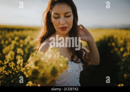 Femme avec fleurs dans le champ Banque D'Images