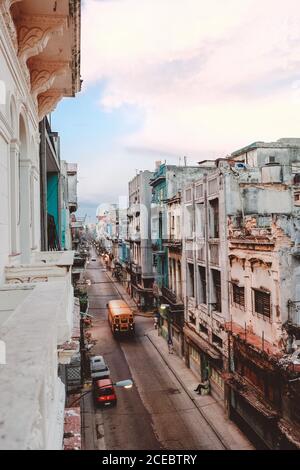 CUBA, le 14 septembre 2017 : rue étroite et pittoresque, avec des bâtiments à plusieurs étages aux intempéries des deux côtés et des voitures rétro donnant sur la route depuis le balcon Banque D'Images