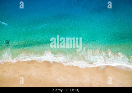 Vue aérienne de la magnifique vague de mer turquoise clair avec de la mousse blanche propre qui roule sur une plage de sable clair le jour d'été ensoleillé à la Graciosa, îles Canaries Banque D'Images