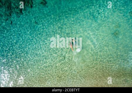 Vue aérienne arrière de l'homme et de la femme détendus nageant ensemble sous l'eau de mer turquoise belle le jour d'été ensoleillé à la Graciosa, îles Canaries Banque D'Images