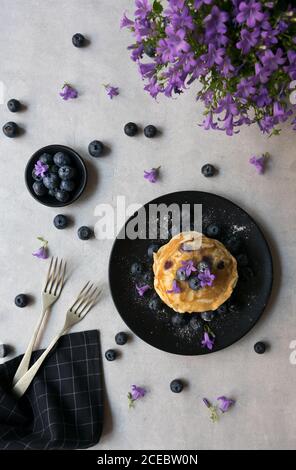 Pile de crumets appétissants avec des fleurs de myrtille et de myrtille décoration sur une table Banque D'Images