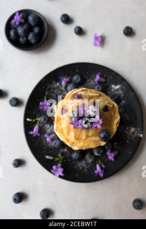 Pile de crumets appétissants avec des fleurs de myrtille et de myrtille décoration sur une table Banque D'Images