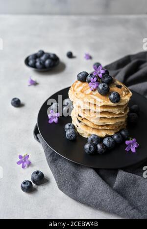 Pile de crumets appétissants avec des fleurs de myrtille et de myrtille décoration sur une table Banque D'Images