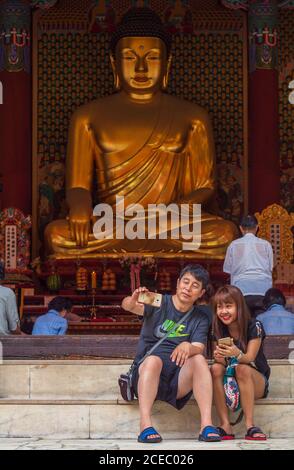 Séoul, Corée du Sud - août 08 2017 : les touristes asiatiques assis sur des marches près de l'incroyable éclat bouddhiste et de prendre le selfie ensemble Banque D'Images