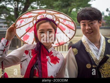 Jeonju, Corée du Sud - août 05 2017 : jeune homme et femme asiatique dans des apparels traditionnels regardant la caméra tout en se tenant dans la rue de la ville Banque D'Images
