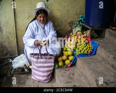 Pérou - janvier 02 2012 : femme âgée de souche en chapeau assise dans des escaliers de chichis et vendant des fruits dans la rue de la ville Banque D'Images