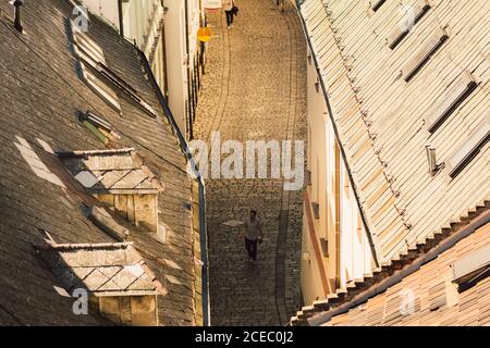 BRATISLAVA, SLOVAQUIE, 30 SEPTEMBRE 2016 : l'homme marche dans la rue pavée de la vieille ville de Bratislava. Vue de dessus. Vue en hauteur sur les toits rouges Banque D'Images