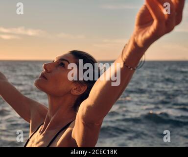 Jeune femme faisant du yoga pendant le coucher du soleil Banque D'Images