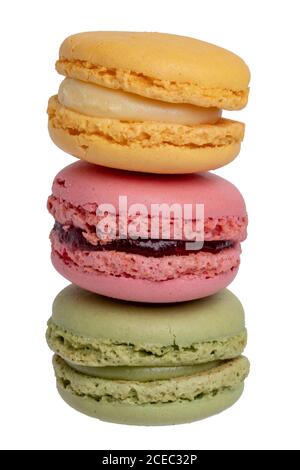 Pâtisseries, desserts et bonbons. Gros plan d'un macaron jaune de citron français, d'un macaron rouge de framboise et d'un macaron vert de pistache isolé sur un blanc Banque D'Images