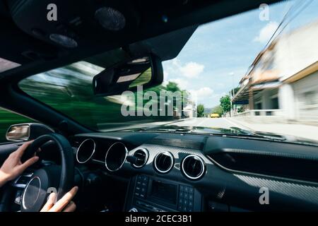 Prise de vue depuis l'intérieur de la voiture d'un conducteur qui roule rapidement en bas de la rue avec vue floue derrière le verre Banque D'Images