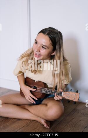 Jeune femme riant avec ukulele Banque D'Images