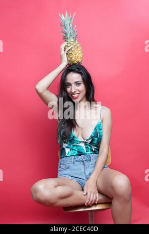 Jeune femme posant en studio et tenant l'ananas Banque D'Images