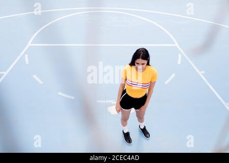 Jeune femme debout sur un terrain de sport Banque D'Images